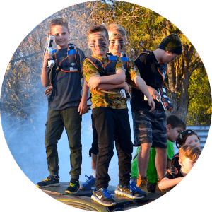 Cool Boys Birthday Party picture with four boys posing on top of a car, with smoke in the background.
